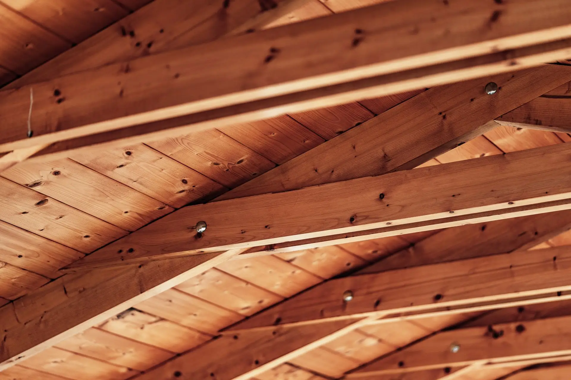 Charpente en bois : chevrons et pannes vus du dessous d’une toiture