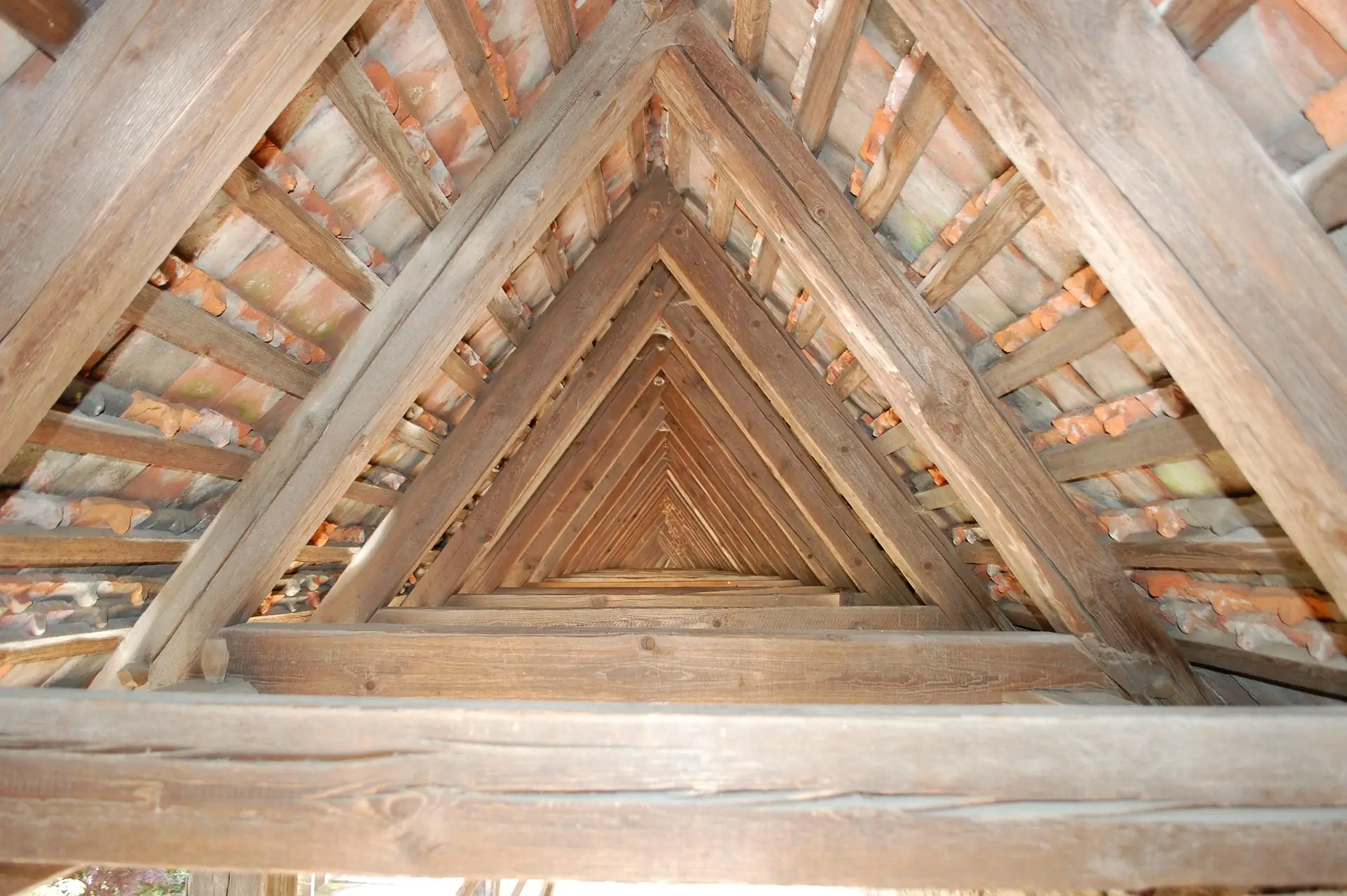 Charpente traditionnelle en bois vue du comble sous une couverture en tuiles