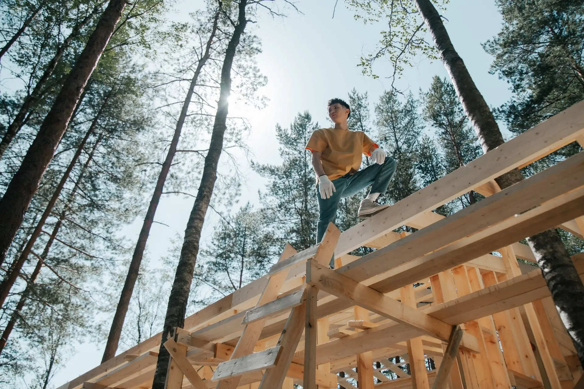 Charpentier debout sur l’ossature en bois d’une toiture neuve
