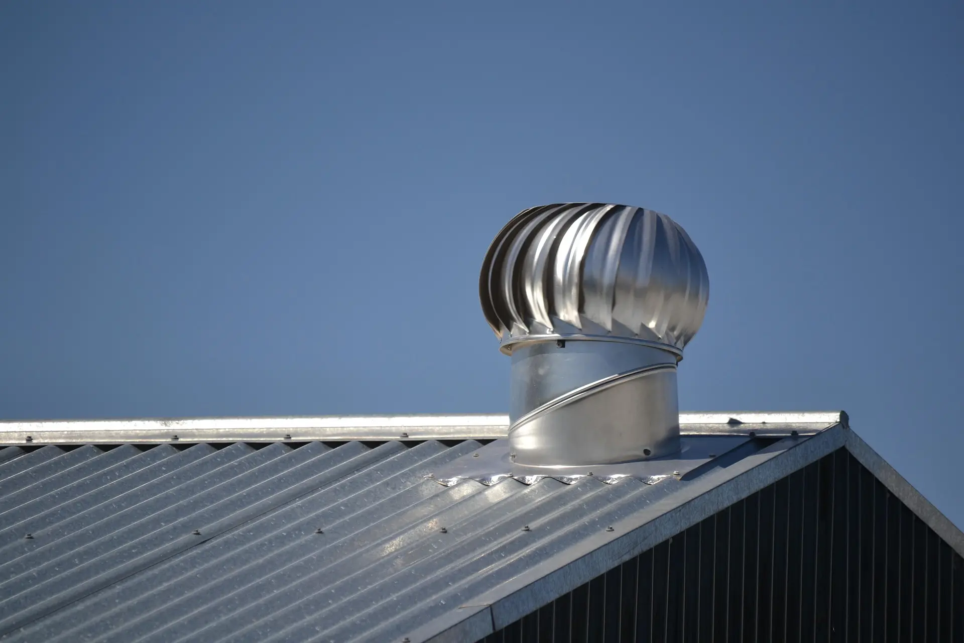 Zinguerie et ventilation de toiture : extracteur éolien en inox sur toiture métallique