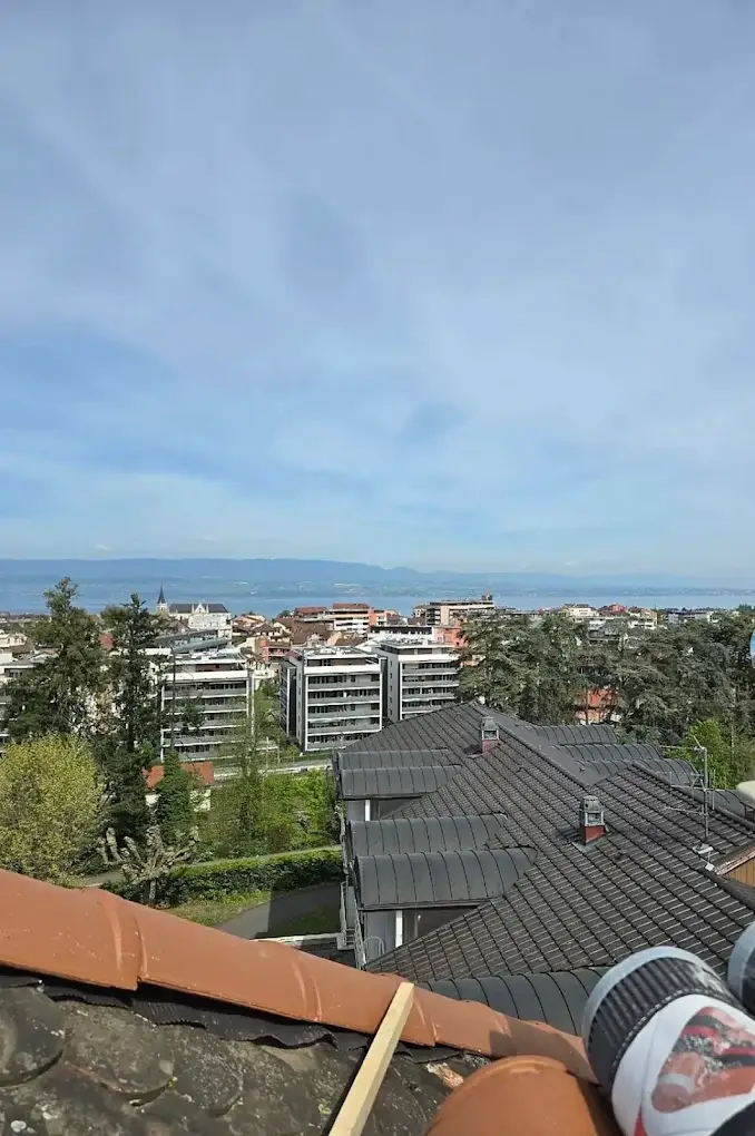 Toiture en tuiles grises avec vue sur le lac depuis le chantier de couverture