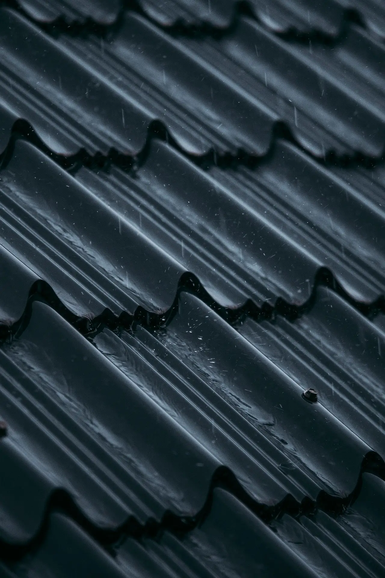 Tuiles métalliques anthracite recouvertes de gouttes d’eau