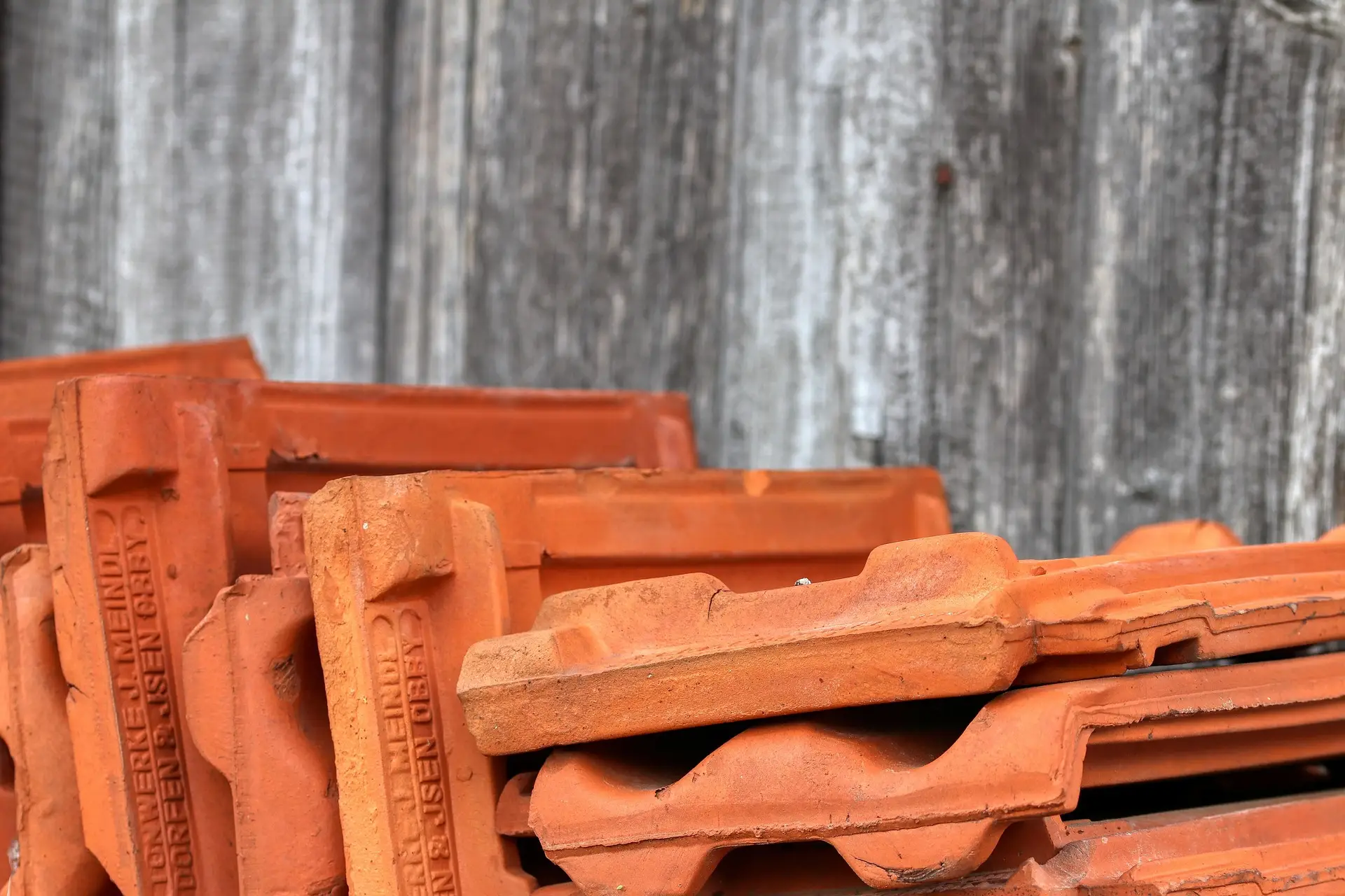 Tuiles en terre cuite empilées et prêtes à la pose sur un chantier